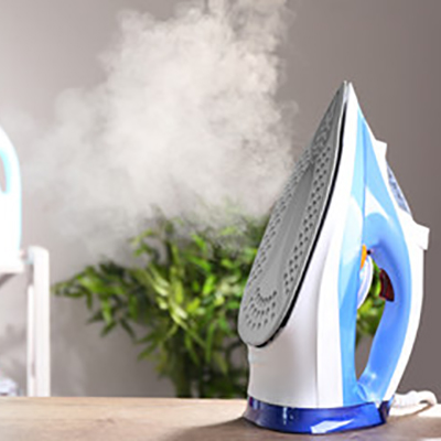 Steam iron on a surface, representing ironing products.