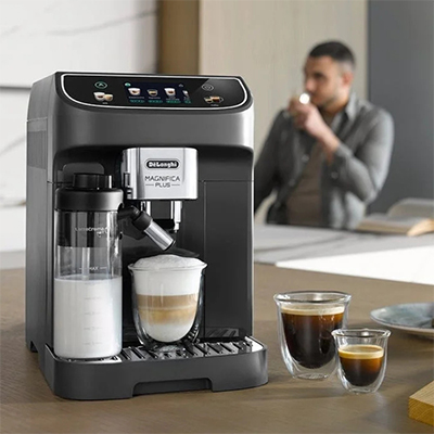 De&rsquo;Longhi black coffee machine making espresso and latte with a man relaxing in the background. Links to Coffee Machine Category Page.