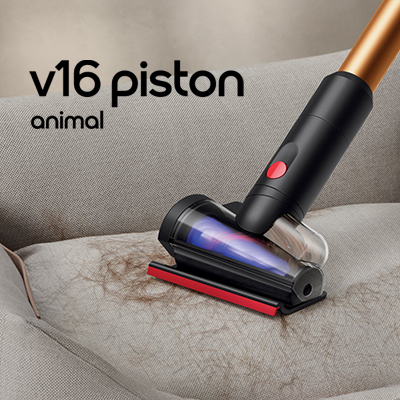 Dyson V16 Piston Animal vacuum removing dog hair from a fabric sofa. Links to Floorcare Category page.