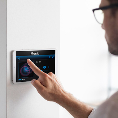 Man selecting music on a smart home touchscreen keypad.Man selecting music on a smart home touchscreen keypad.